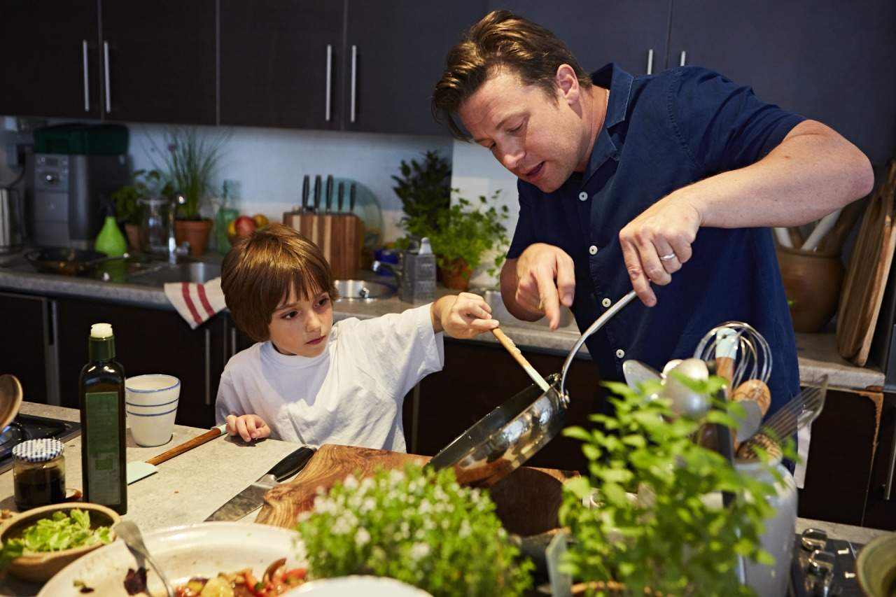 Blogger Honest Mum's son takes an omelette from the pan Jamie Oliver is holding