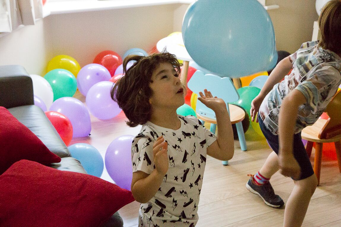 kids playing with a room full of balloons