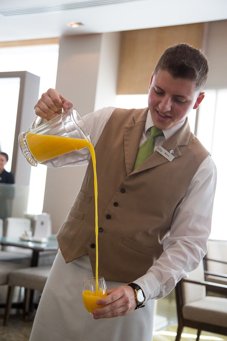 waiter pouring orange juice