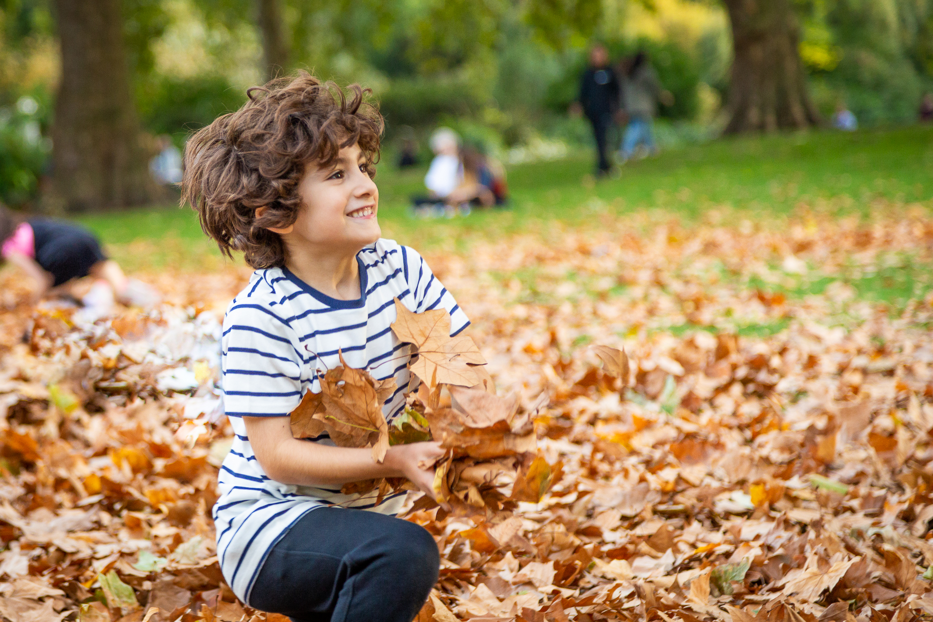 child plays with leaves