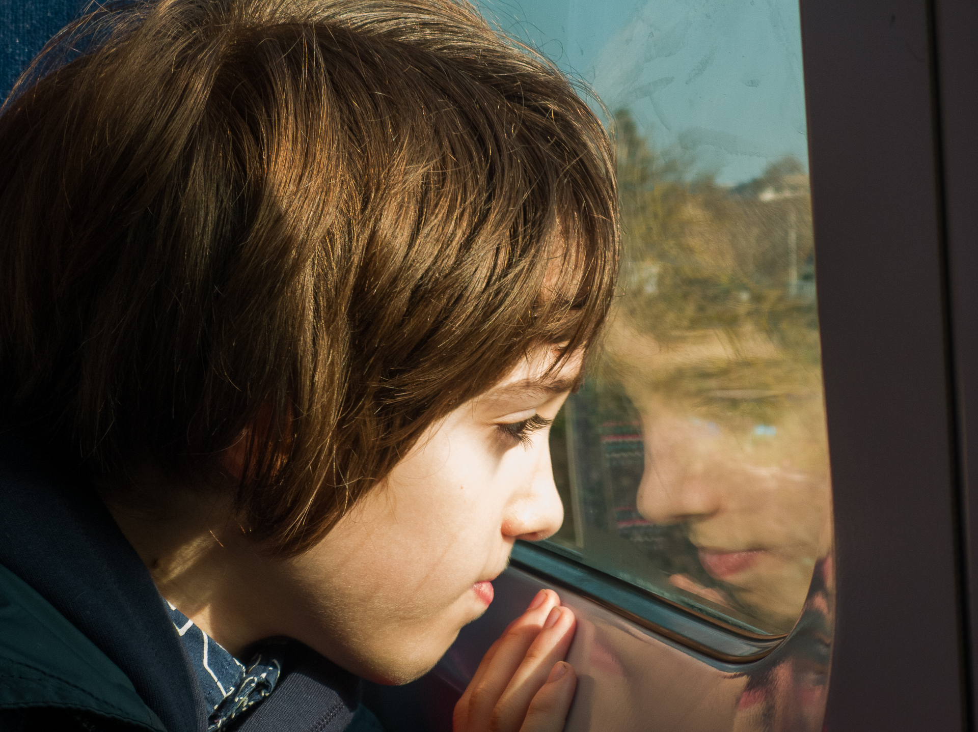 child looks out of the window on a train to London