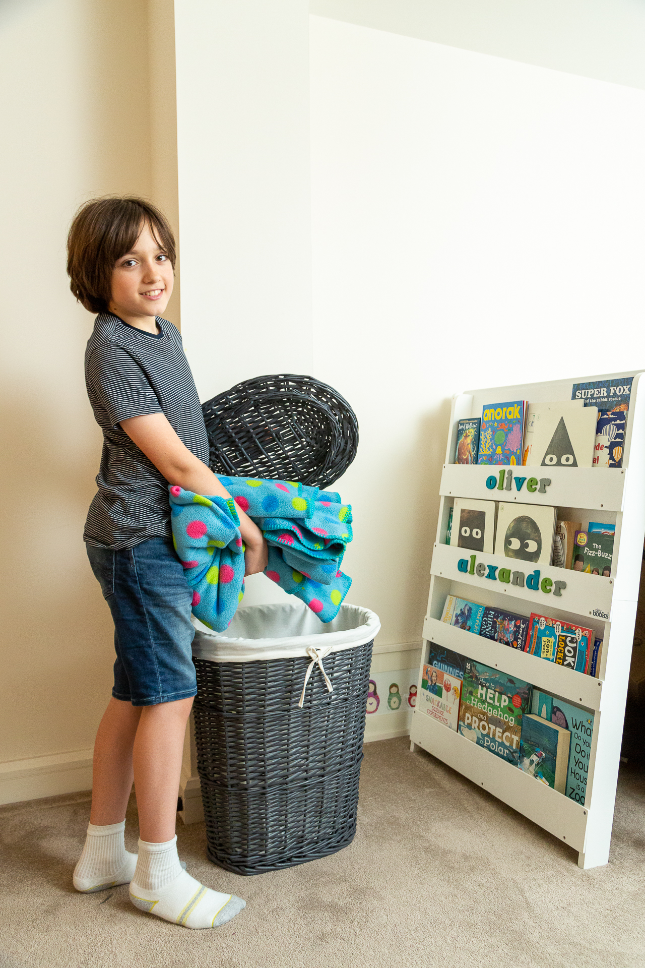 child puts laundry in a basket